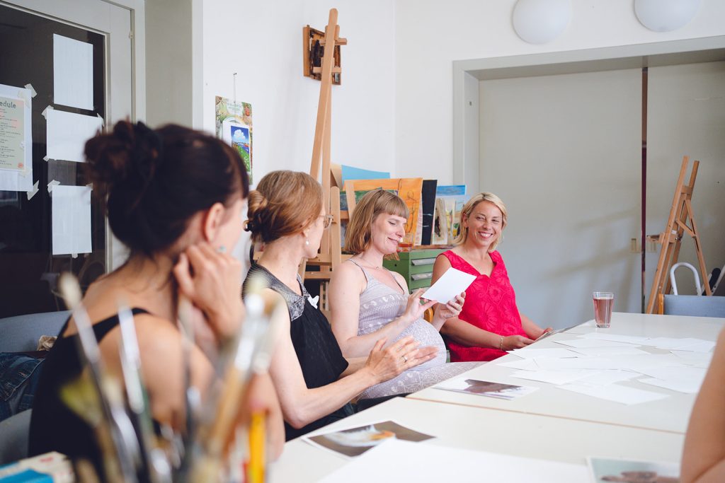 A group seated around a table at an art workshop