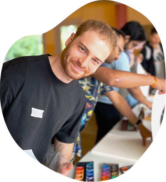 A smiling young man sitting among participants at a workshop