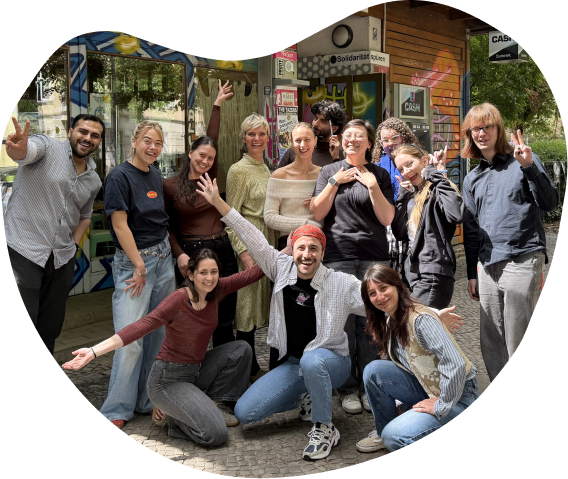 A cheerful group of young people posing together outdoors, smiling and making playful hand gestures