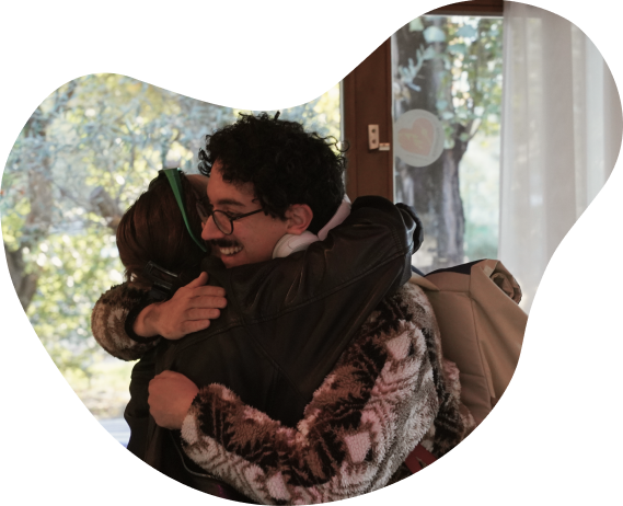 Two people sharing a warm hug beside a sunlit window